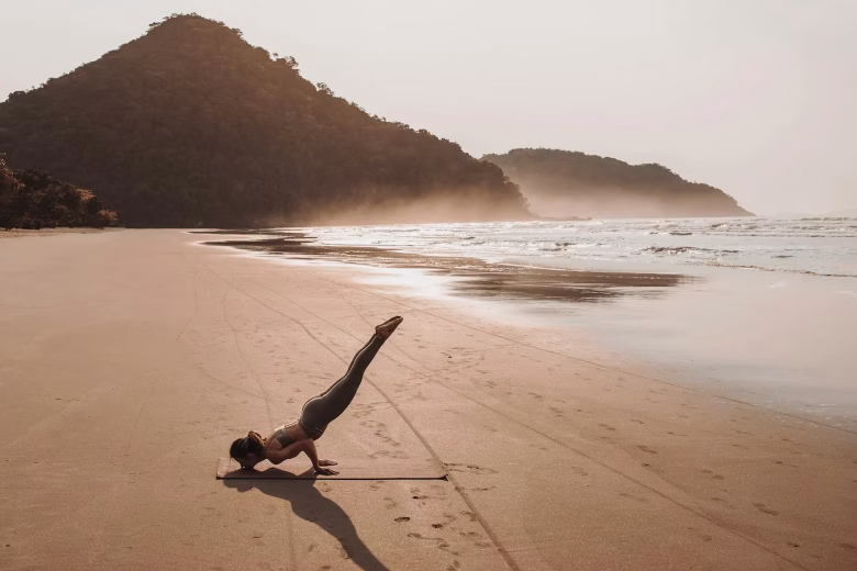 woman in yoga pose on beach